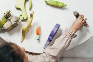 Child playing with colorful wooden toys in a playful indoor setting.