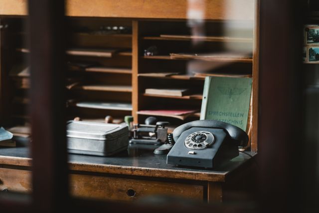 Retro office setting featuring a classic rotary phone and desk accessories.